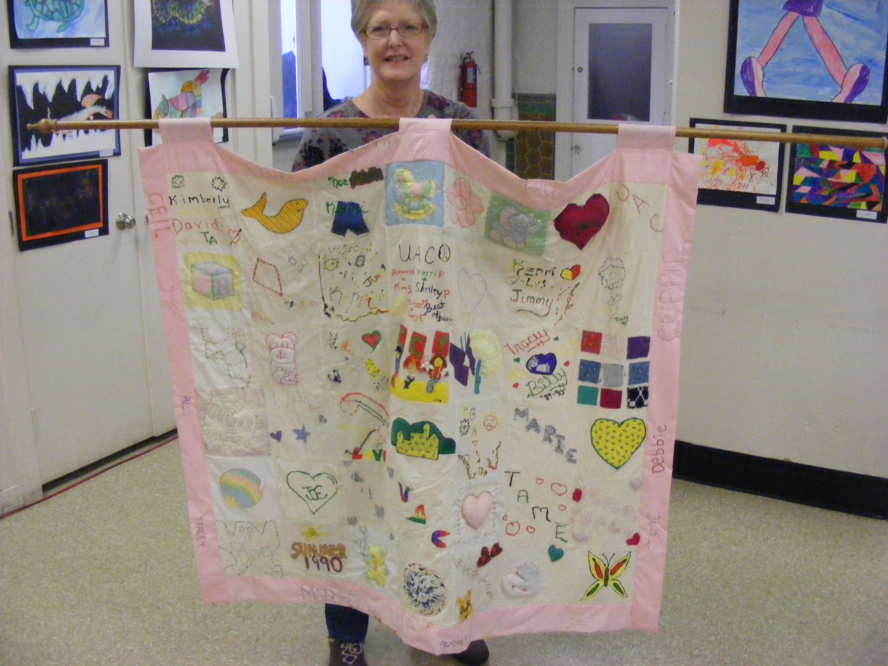 Debbie Zorn holding a quilt at the UACC's 2015 Photo Identification event